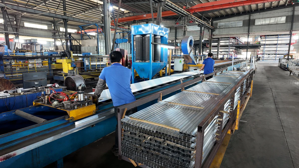 Mitarbeiter bewegen Aluminiumprofile an der Fertigungslinie